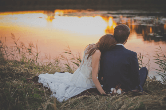 Married couple in front of a lake contemplating, prenuptial agreement