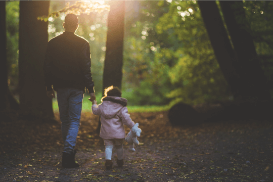 Father and daughter family walking in the woods